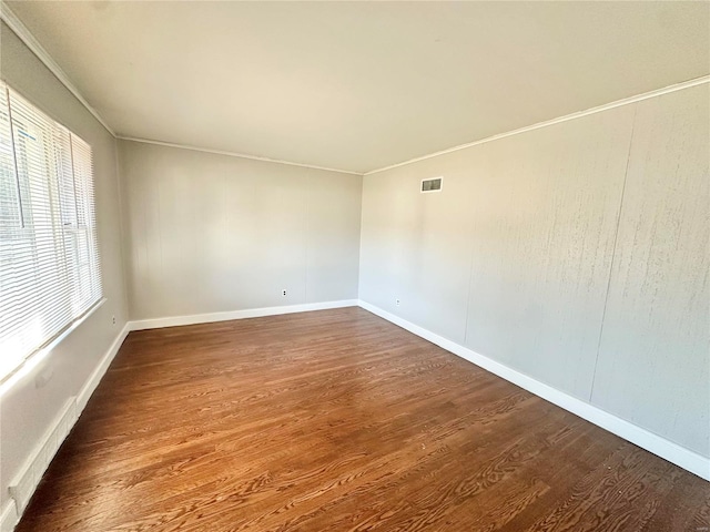 empty room with dark wood-type flooring and ornamental molding