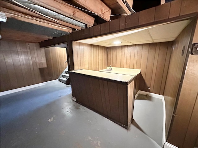 bar featuring concrete flooring and wood walls