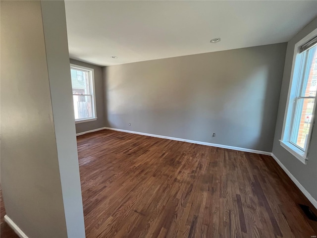 unfurnished room featuring dark wood finished floors and baseboards