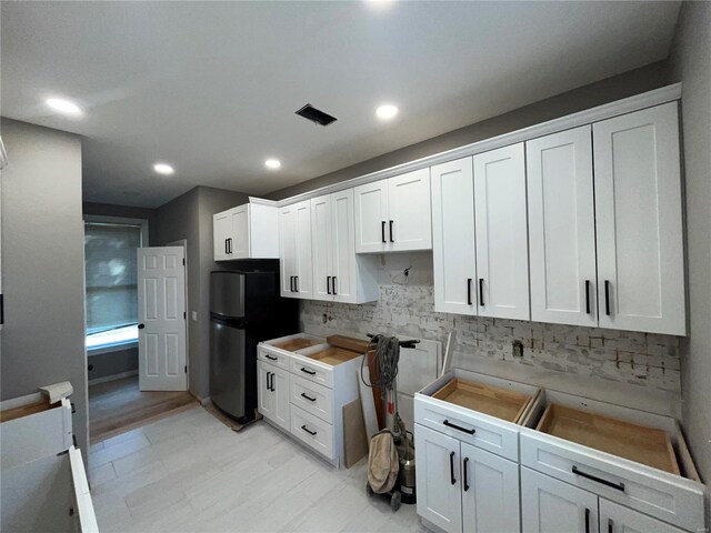 kitchen featuring tasteful backsplash, recessed lighting, white cabinets, and freestanding refrigerator