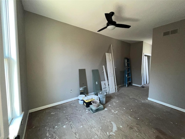 unfurnished living room with visible vents, a ceiling fan, and baseboards