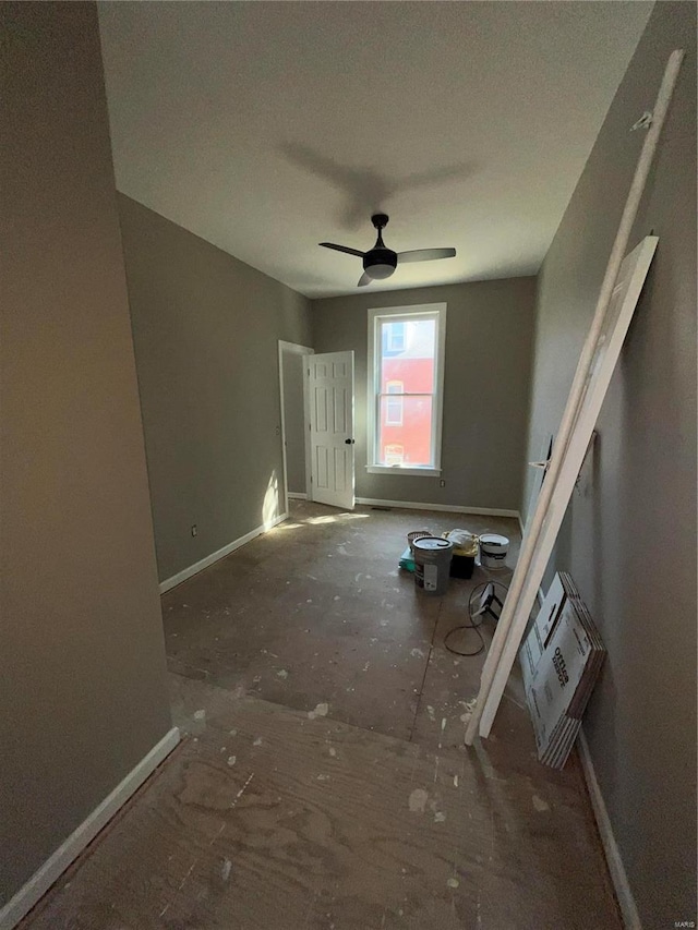 unfurnished living room featuring ceiling fan and baseboards