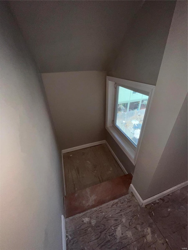 stairs featuring baseboards and vaulted ceiling