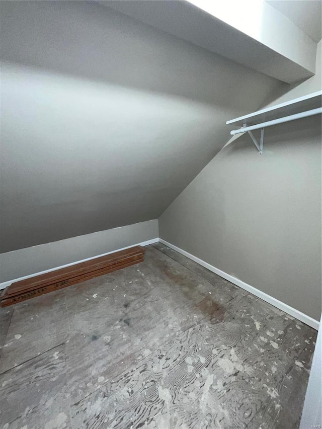 bonus room with lofted ceiling and baseboards