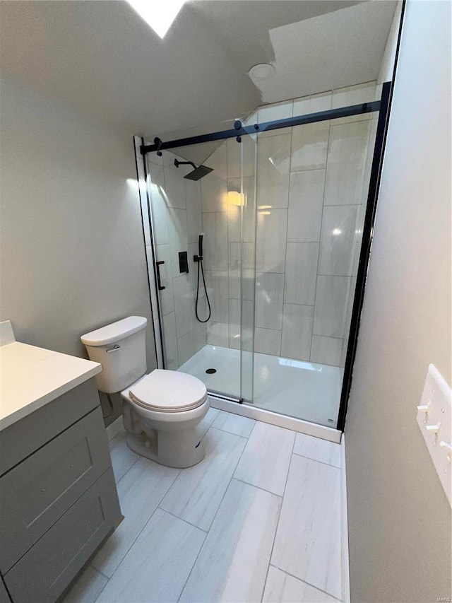 full bath featuring vanity, a shower stall, and toilet