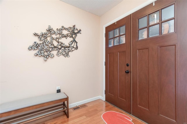 foyer with light hardwood / wood-style flooring and a textured ceiling