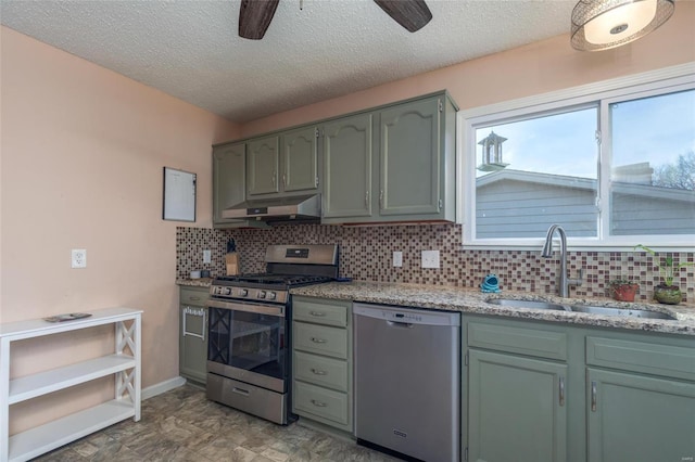 kitchen featuring sink, ceiling fan, backsplash, stainless steel appliances, and green cabinetry