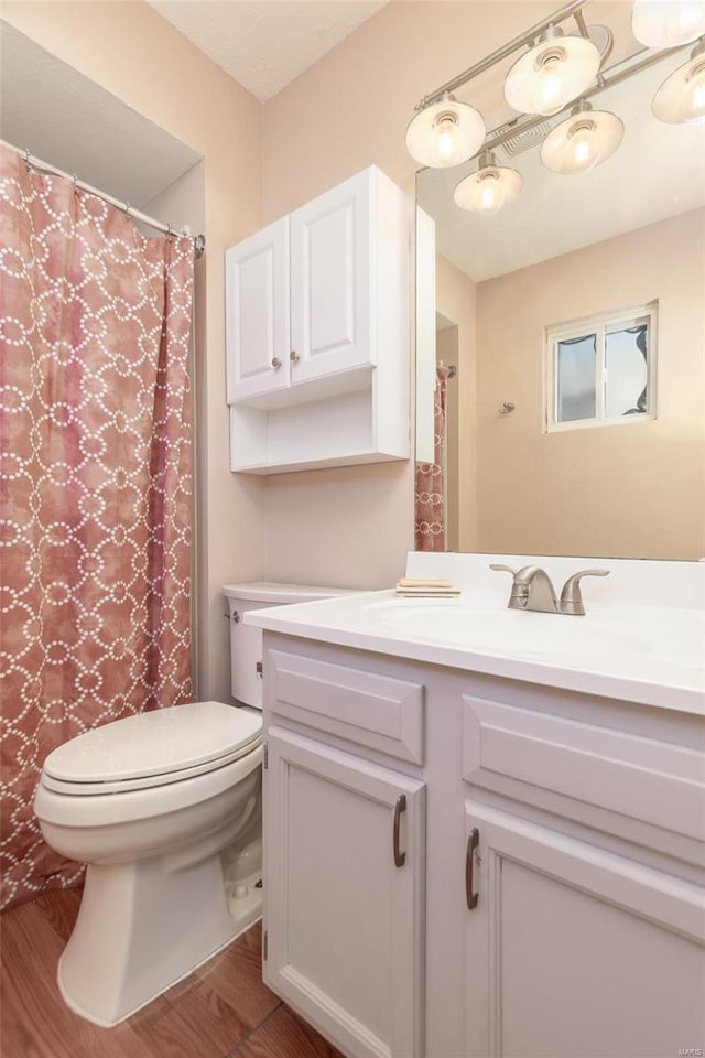 bathroom featuring wood-type flooring, vanity, and toilet