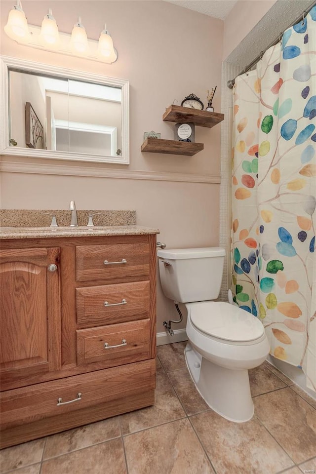 bathroom featuring tile patterned flooring, vanity, and toilet