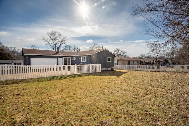 back of property featuring a garage and a yard