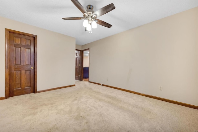 unfurnished bedroom featuring baseboards, ceiling fan, connected bathroom, and light colored carpet