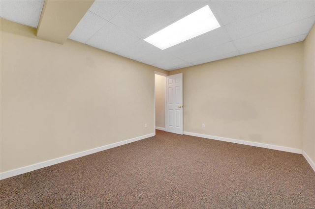 carpeted empty room with a paneled ceiling and baseboards