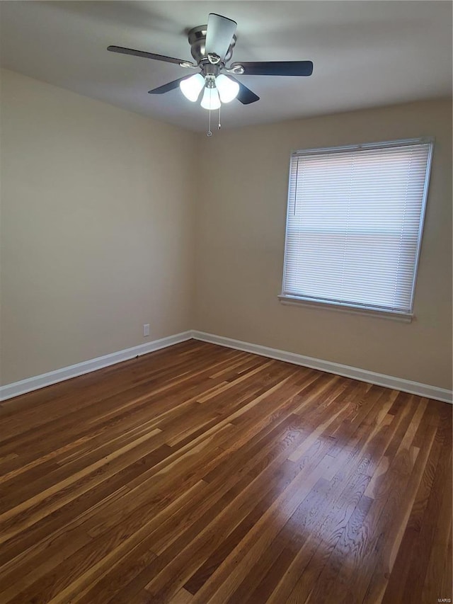 spare room featuring baseboards, dark wood-type flooring, and ceiling fan