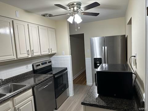 kitchen featuring a sink, light wood finished floors, white cabinetry, stainless steel appliances, and ceiling fan