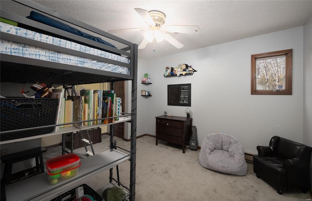 bedroom featuring ceiling fan, a baseboard radiator, light carpet, and a textured ceiling