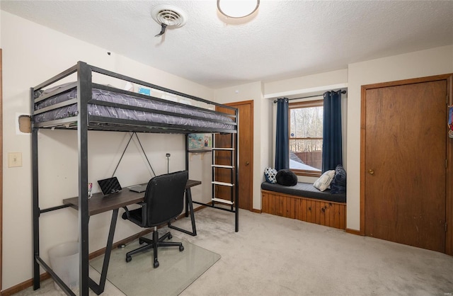 bedroom with carpet floors and a textured ceiling