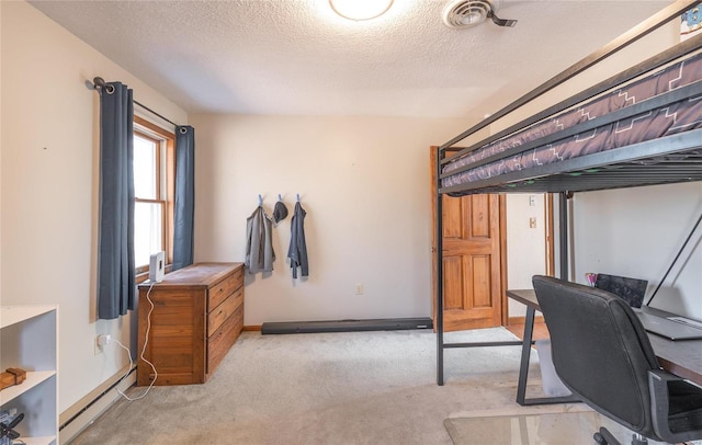 carpeted bedroom with a baseboard heating unit and a textured ceiling