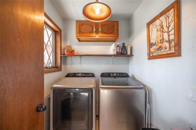 laundry area with cabinets, washer and dryer, and a textured ceiling