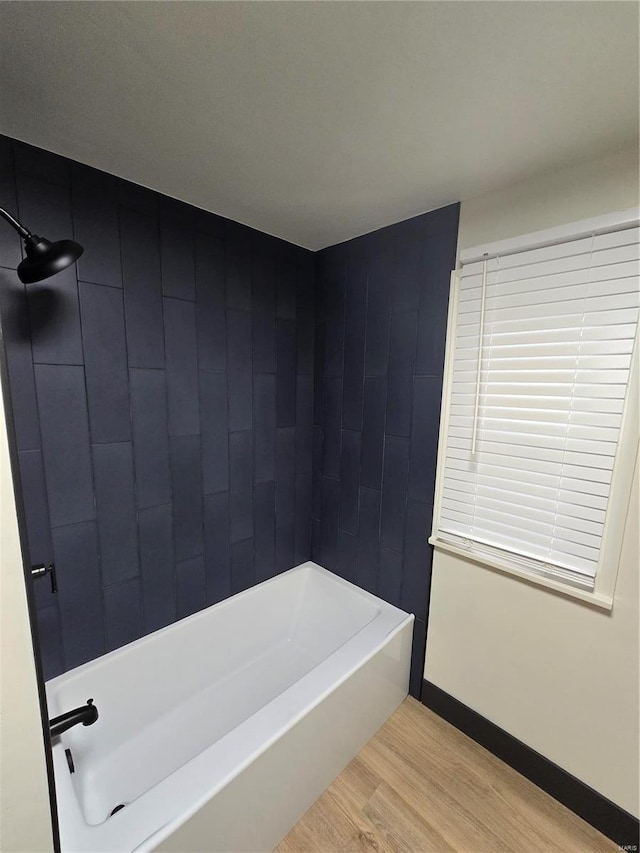 bathroom featuring wood-type flooring and  shower combination