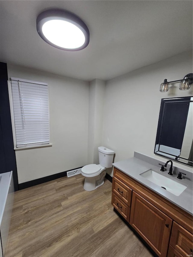 bathroom featuring hardwood / wood-style flooring, vanity, and toilet