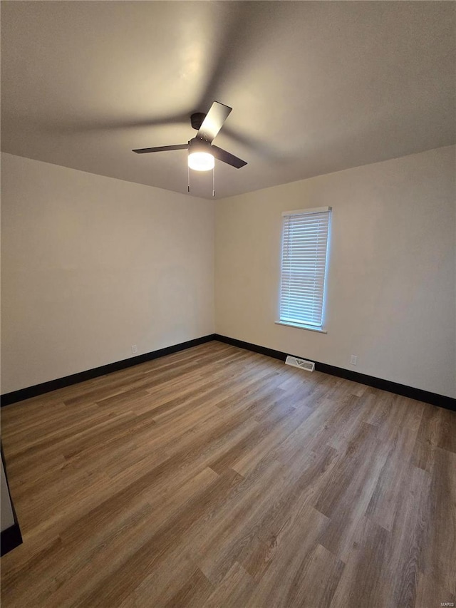 empty room with ceiling fan and light hardwood / wood-style flooring