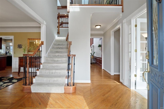 foyer entrance with crown molding and light wood-type flooring