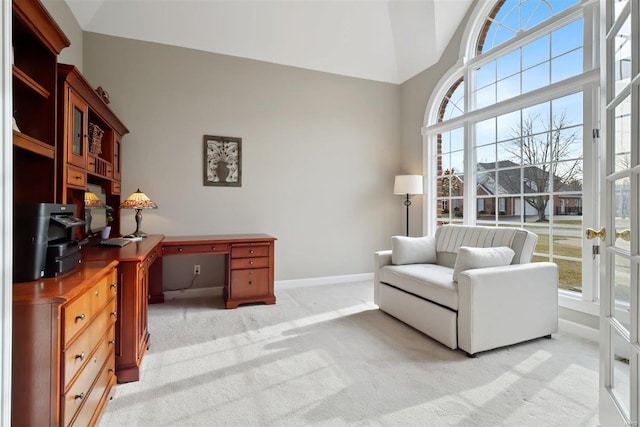 office with high vaulted ceiling, light colored carpet, and a healthy amount of sunlight