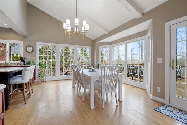 dining area featuring a notable chandelier, a healthy amount of sunlight, and light wood-type flooring