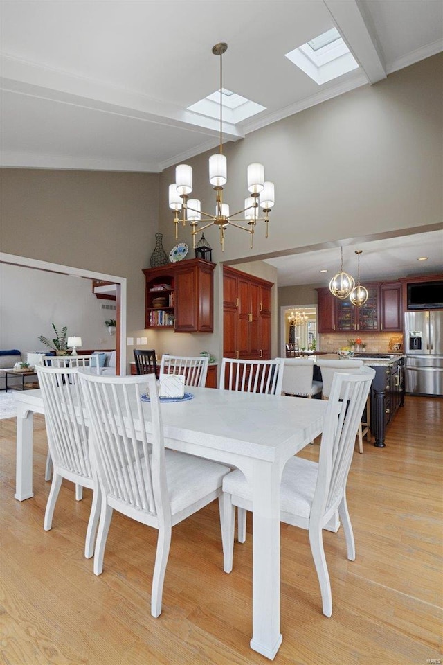 dining area featuring vaulted ceiling, a chandelier, and light hardwood / wood-style floors