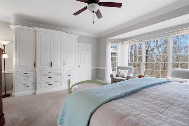 bedroom featuring ornamental molding, light carpet, ceiling fan, and a closet