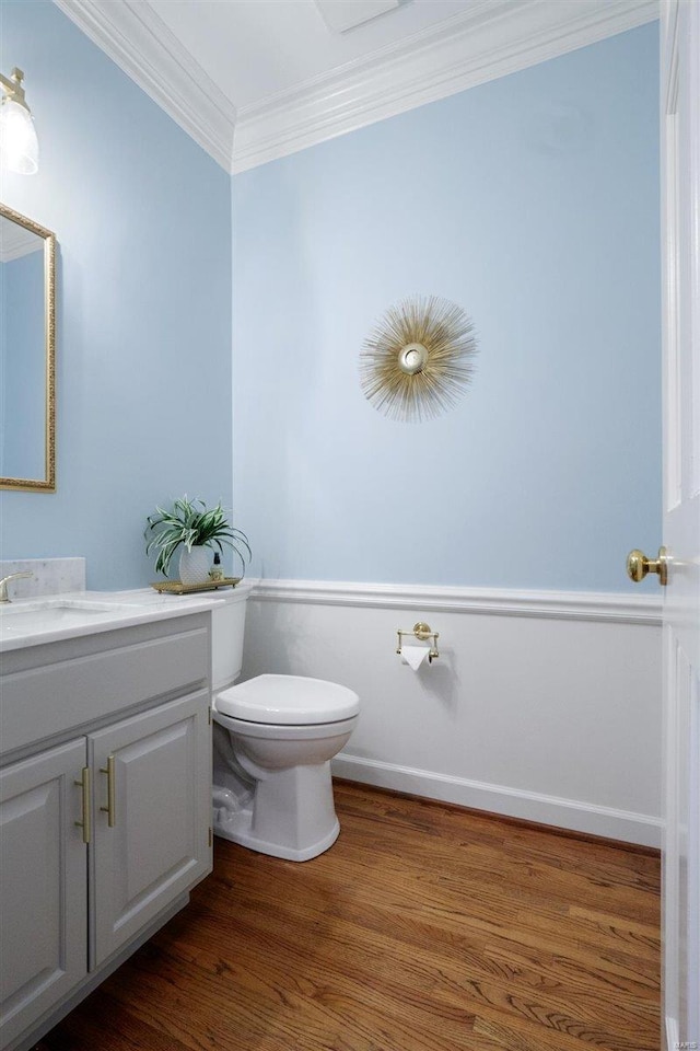 bathroom with crown molding, wood-type flooring, vanity, and toilet