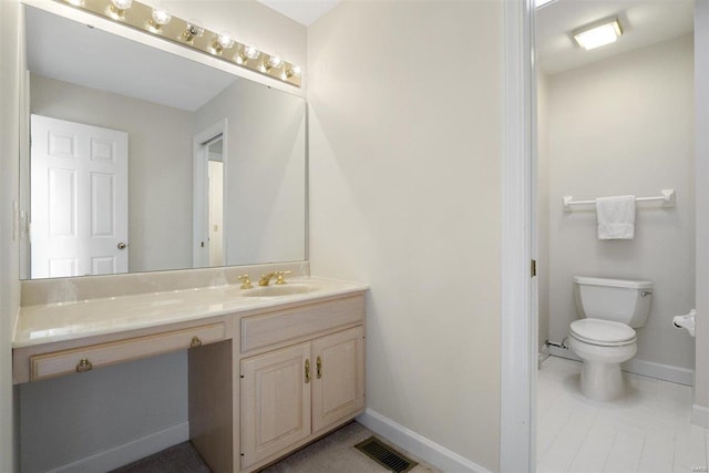 bathroom featuring vanity, tile patterned floors, and toilet