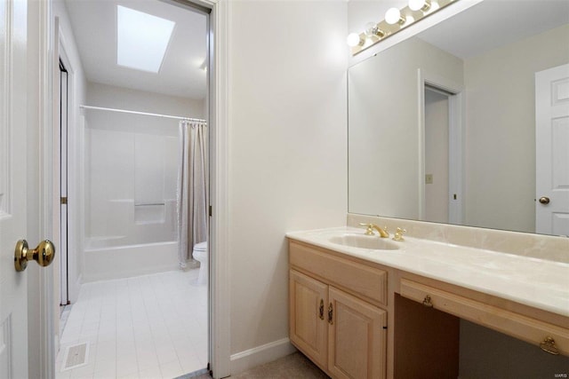 full bathroom featuring toilet, a skylight, vanity, shower / bath combo, and tile patterned flooring