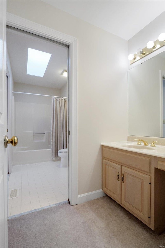 bathroom with vanity, toilet, and a skylight