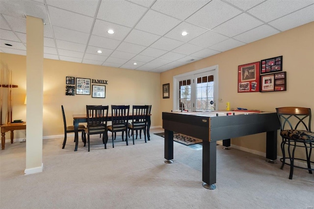 recreation room with a paneled ceiling and light colored carpet