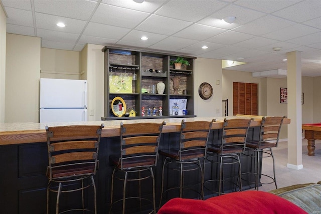 bar with a drop ceiling and white refrigerator