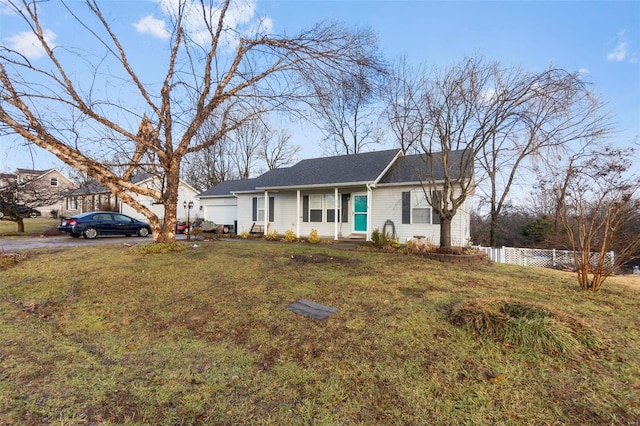 ranch-style house featuring a garage and a front lawn