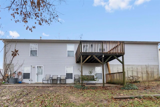 rear view of house with a wooden deck, a patio, and central air condition unit