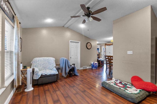 living area with ceiling fan, dark hardwood / wood-style floors, and vaulted ceiling with beams