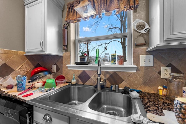 kitchen featuring dishwasher, sink, white cabinets, and decorative backsplash