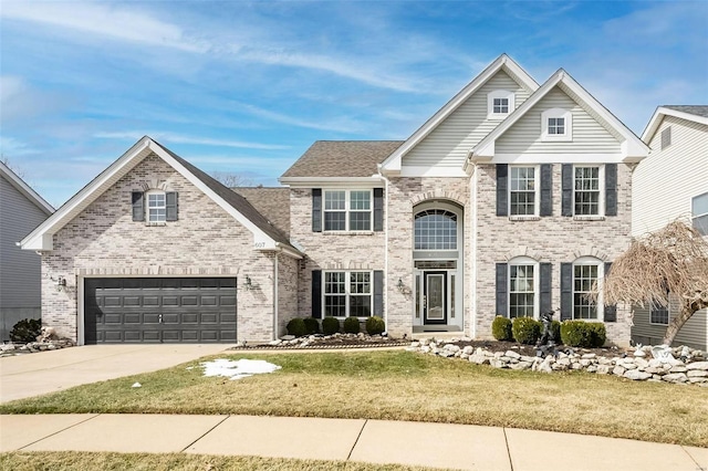 traditional home with concrete driveway, brick siding, a front lawn, and an attached garage