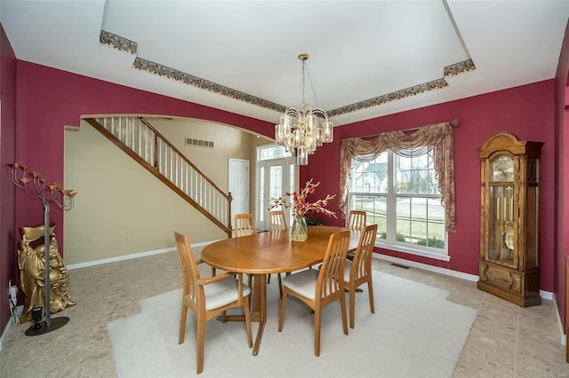 dining area with arched walkways, visible vents, stairway, and baseboards