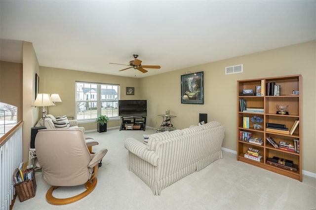 living room with a ceiling fan, carpet flooring, visible vents, and baseboards