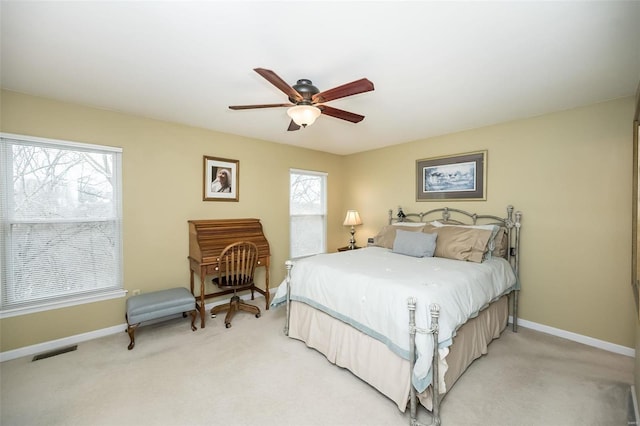 bedroom with light colored carpet, visible vents, and multiple windows