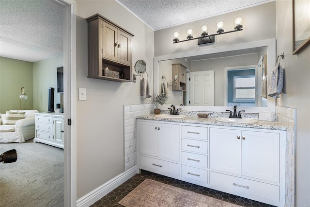 bathroom with tile patterned floors, vanity, and a textured ceiling