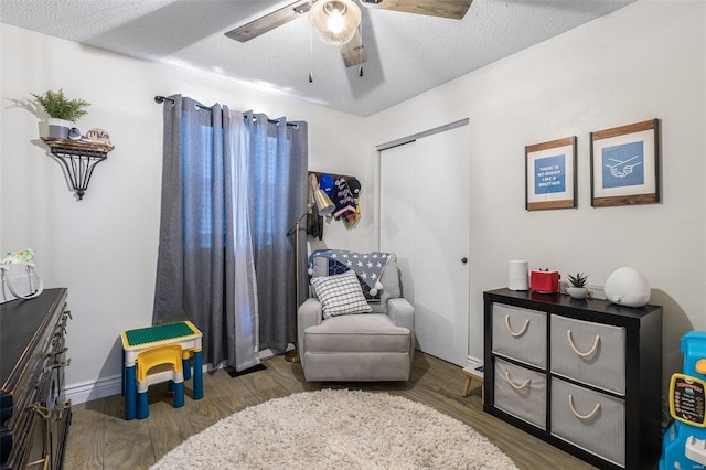 sitting room featuring hardwood / wood-style flooring, a textured ceiling, and ceiling fan