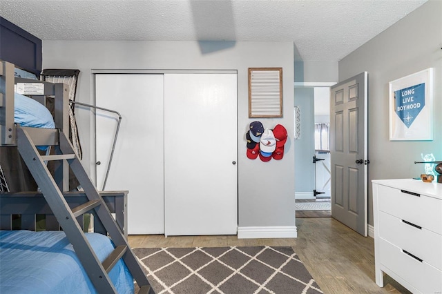 bedroom featuring hardwood / wood-style floors, a closet, and a textured ceiling