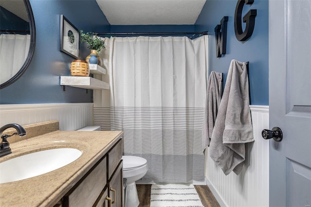 bathroom with hardwood / wood-style flooring, vanity, a textured ceiling, and toilet