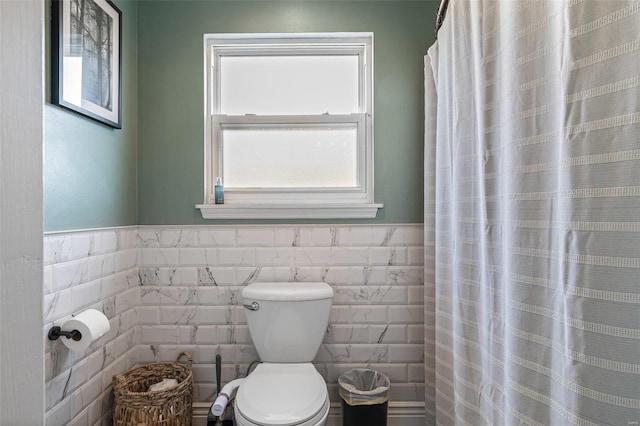 bathroom featuring toilet and tile walls