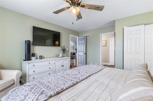 bedroom with ceiling fan, a closet, and a textured ceiling